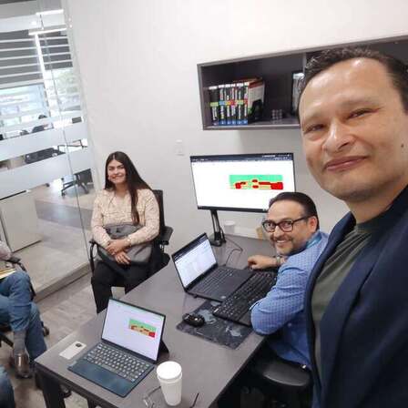 Gustavo trabajando con el equipo de Grupo Hermosillo frente a sus computadoras