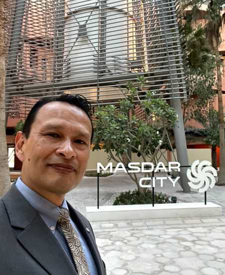 Gustavo de traje junto al letrero de Masdar City, en Abu Dabi