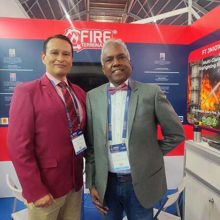 Gustavo con un colega en un estand de sistemas contra incendios en una feria en Singapur